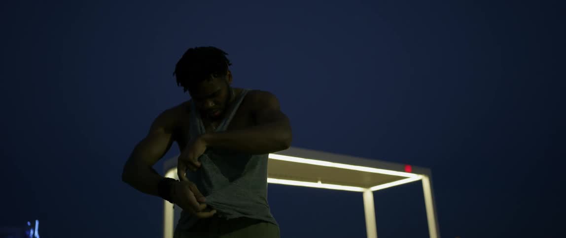 Man dances and removes shirt at night