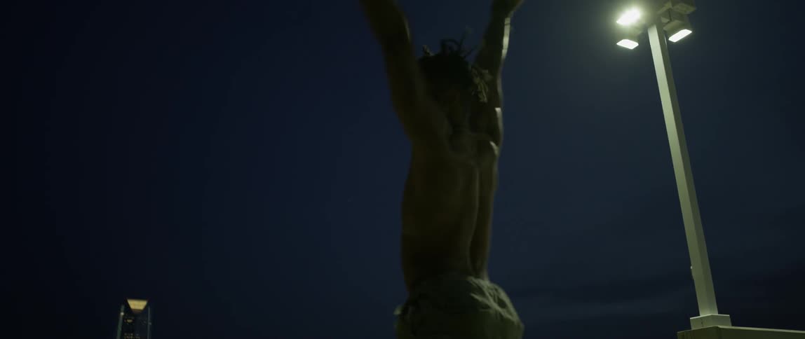 A man is jumping and twirling around at night
