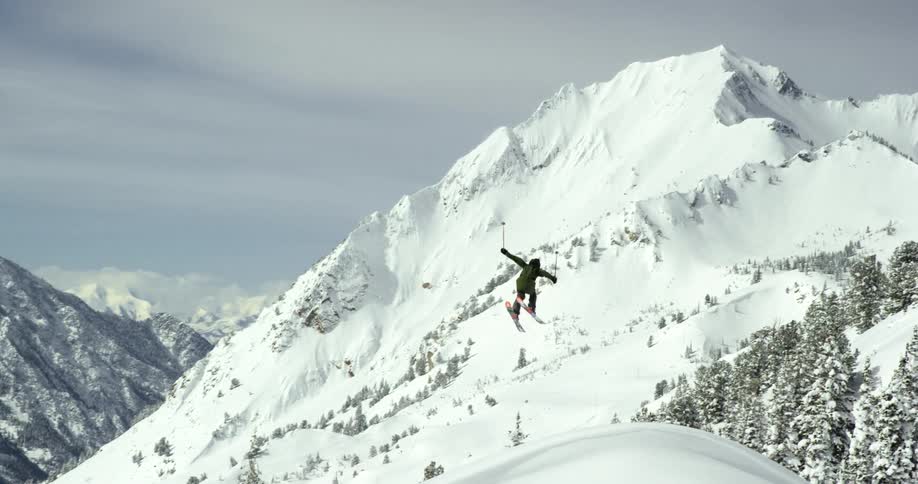 A man jumps off the mountain to being skiing