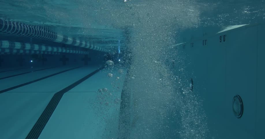 A woman dives into a pool