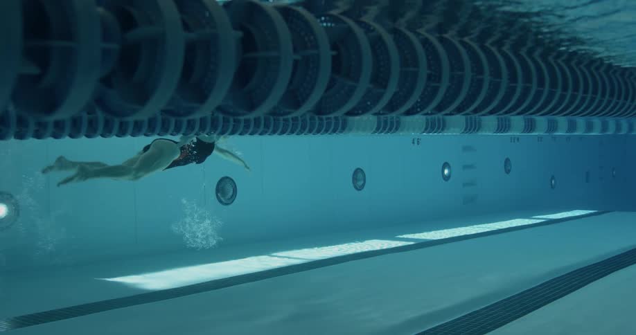Female swimmer swimming in an olympic-sized pool as seen underwater
