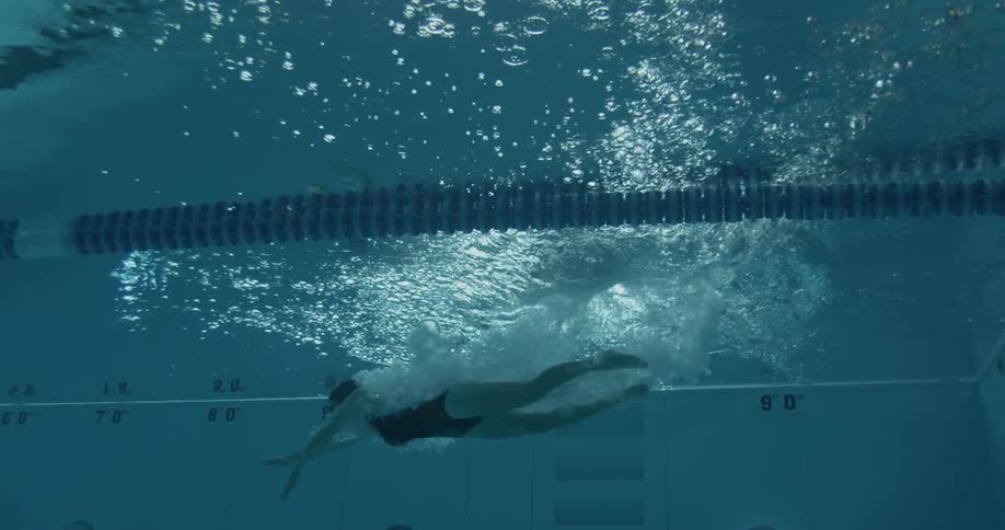 A woman dives into a pool