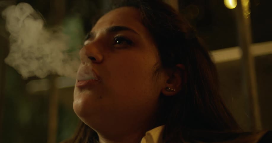 A woman smokes from a hookah pipe