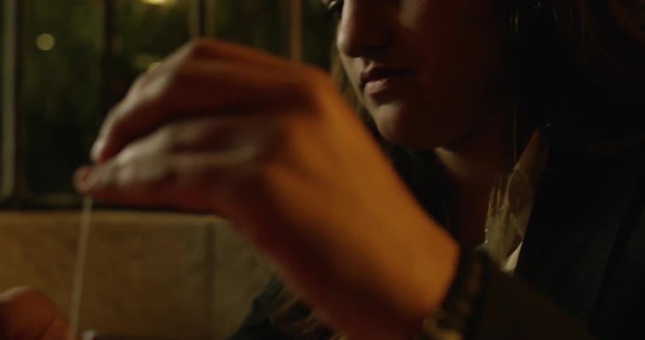 Woman stirs a drink at a table