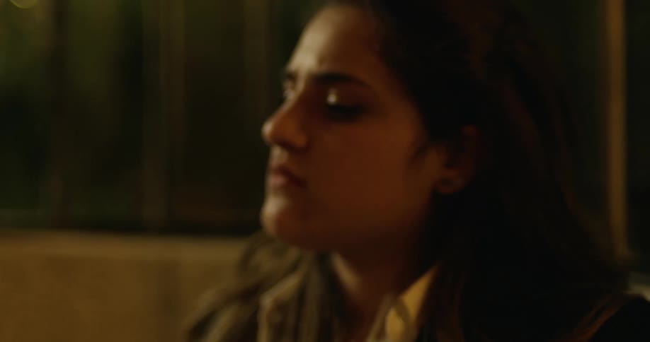 Disappointed woman sits in a dimly lit room