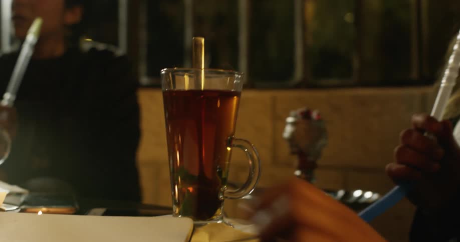 Women smoke and socialize in a hookah bar at night