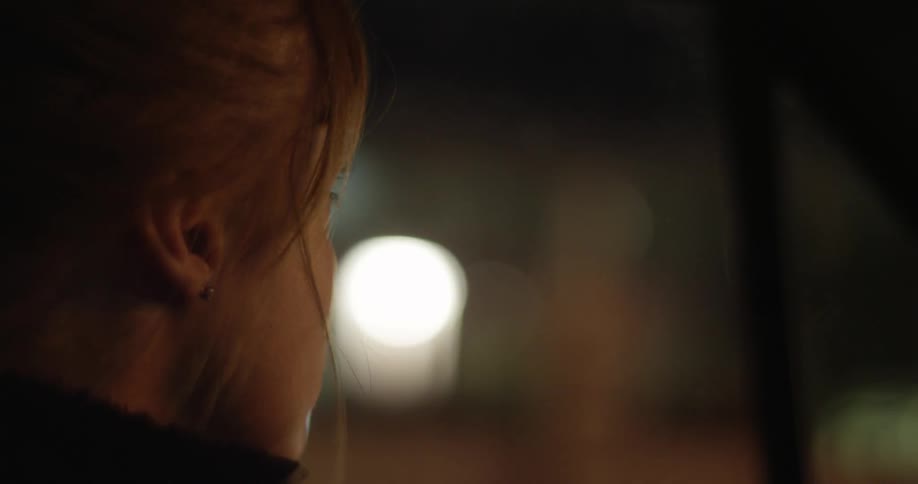 Woman looks around an area and says something briefly