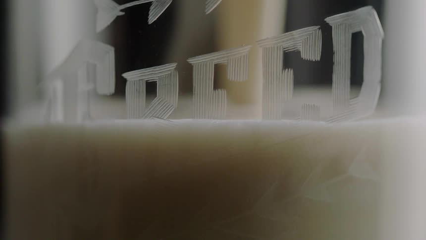 Beer being poured into a glass mug with a design on it