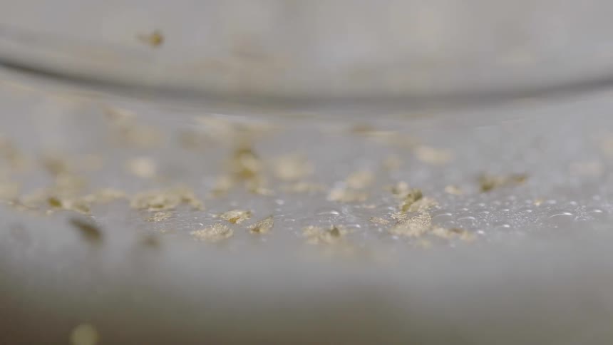 A bunch of small leaves are falling onto a plastic surface