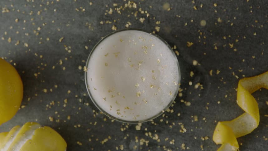 Lemon zest is sprinkled onto a drink