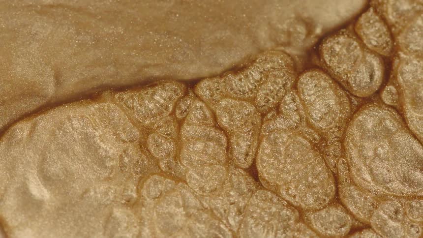 Glittery gold liquid boils and moves