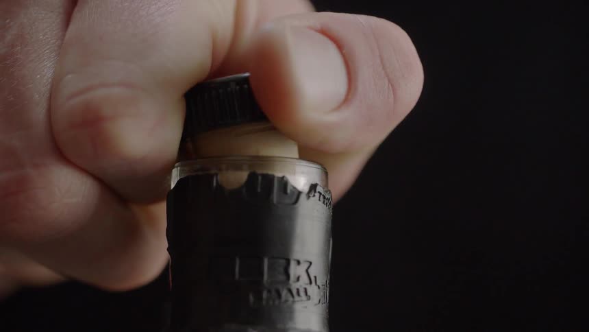 A person removes the cork from a bottle