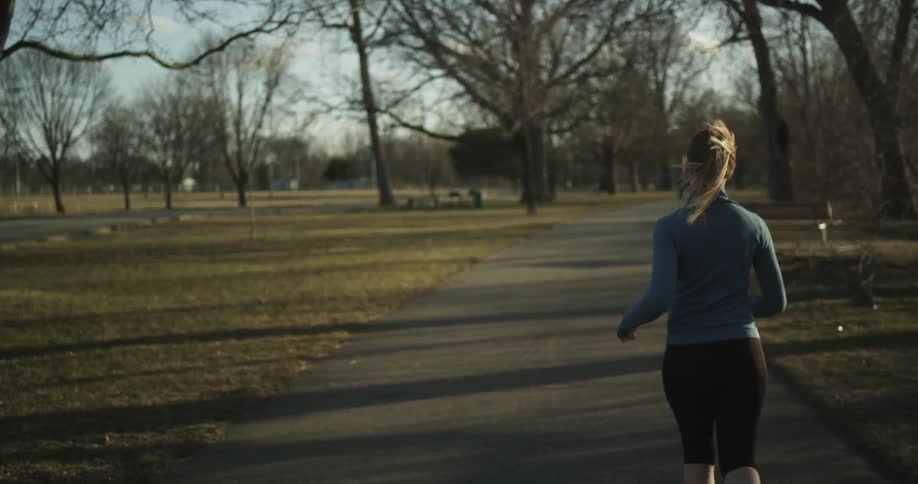 A woman runs in a park