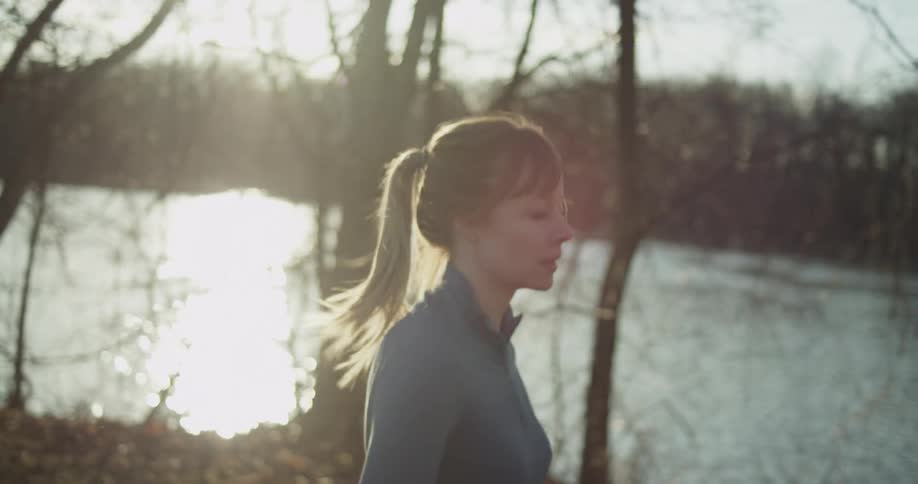 A woman jogs next to a river