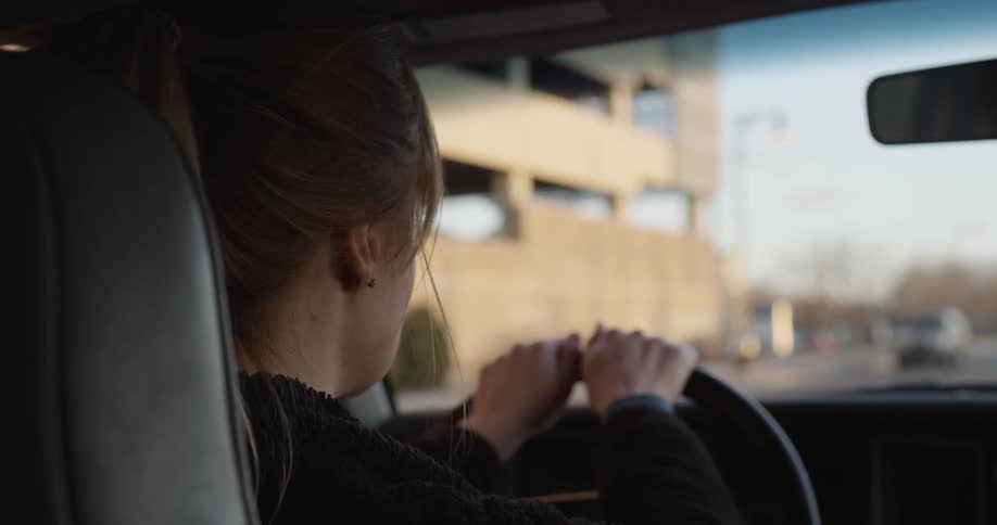 A woman is driving down the road