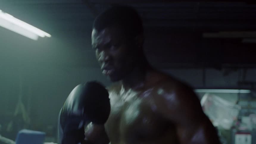 Sweaty boxer bounces in boxing ring