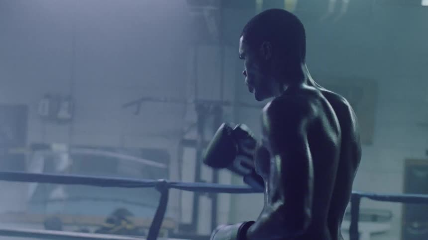 Shirtless boxer warms up in boxing ring