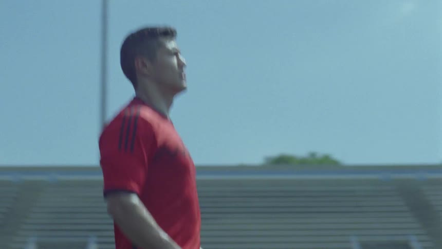 A man kicks a soccer ball in an arena