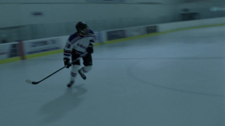 A hockey player is skating around a rink