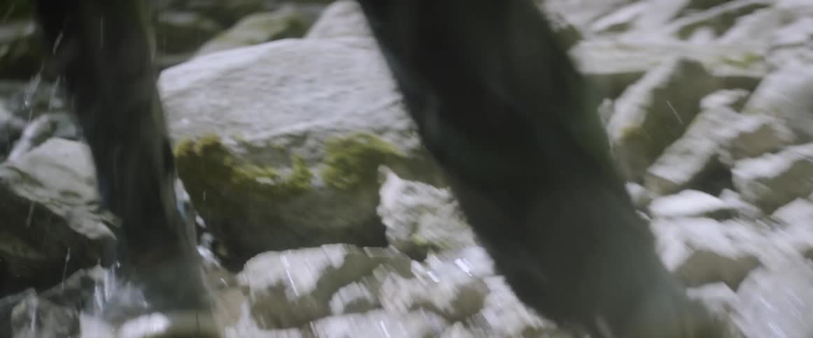 Person runs through a rocky creek bed
