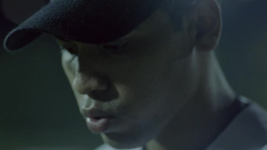 A baseball player begins to throw the ball at night