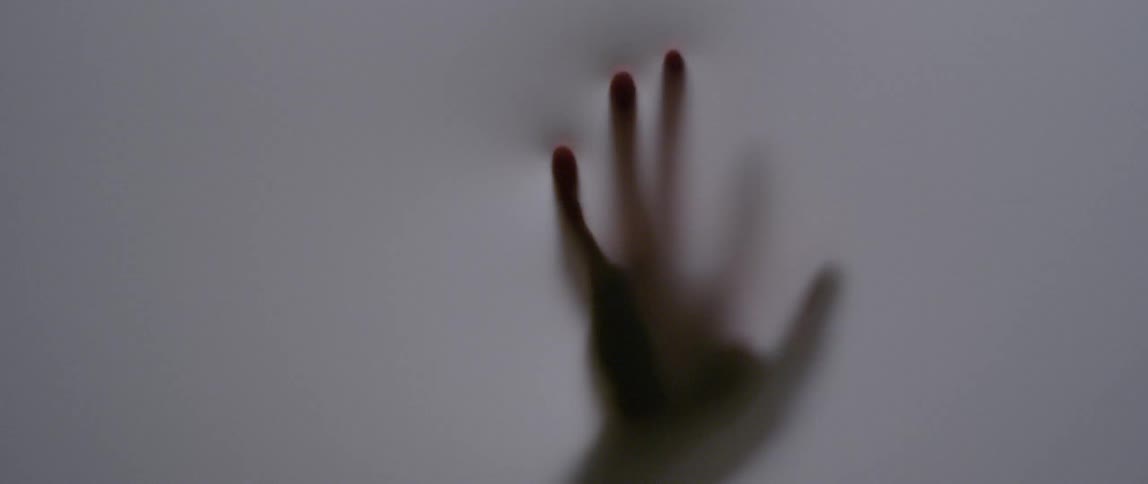 A person is pressing their hand against an opaque fabric enclosure