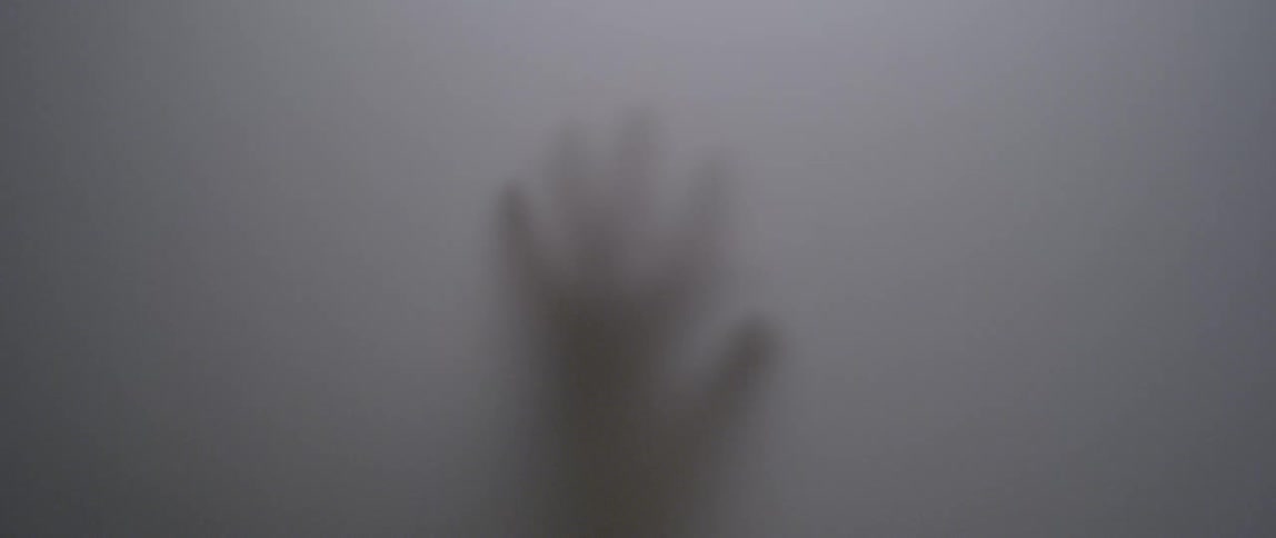 A person traces their hand across the plastic sheet a couple of times