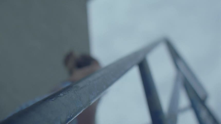 Woman grabs the handrail as she climbs the stairs