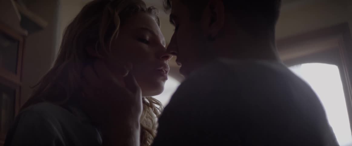 A man and woman are kissing in a bedroom