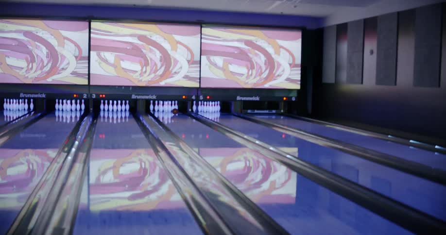 A man and his friends are bowling during the day