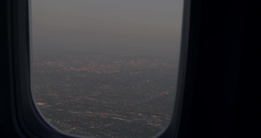 Outside the plane window is a town below