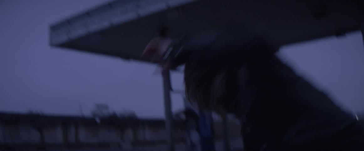 A woman moves frantically at a gas station