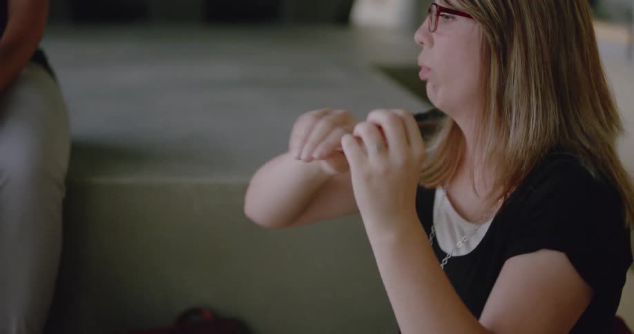 A woman is performing sign language to others