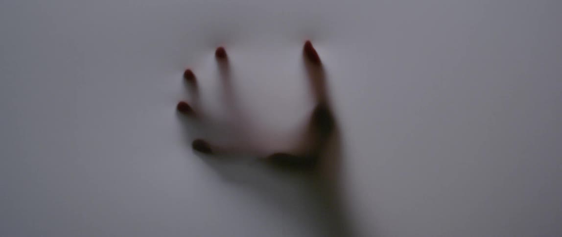 A hand is pushing against a white screen