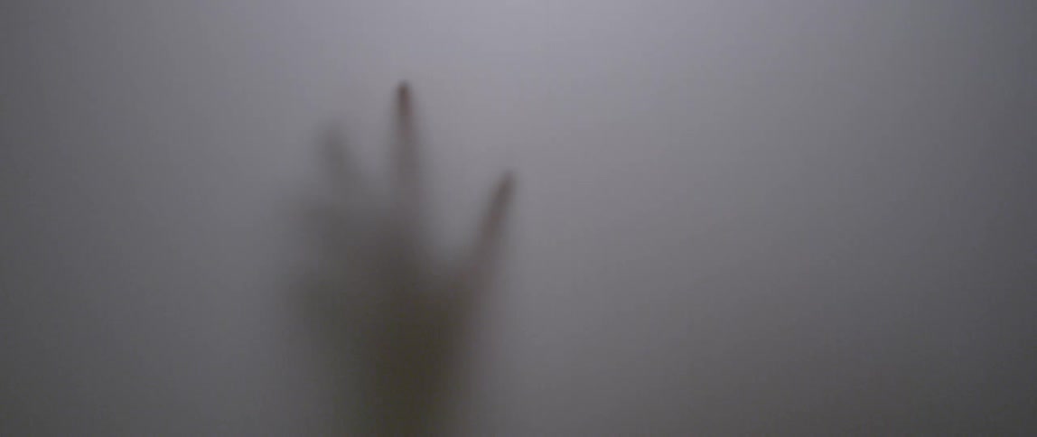 A hand is touching and pushing on an opaque fabric