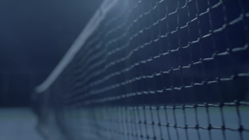 Tennis ball being tossed at a net