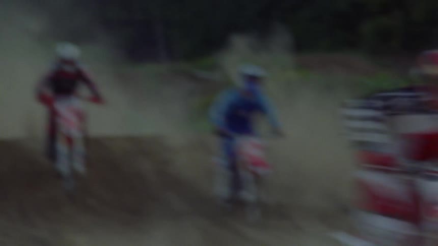 People on dirt bikes are doing jumps and racing