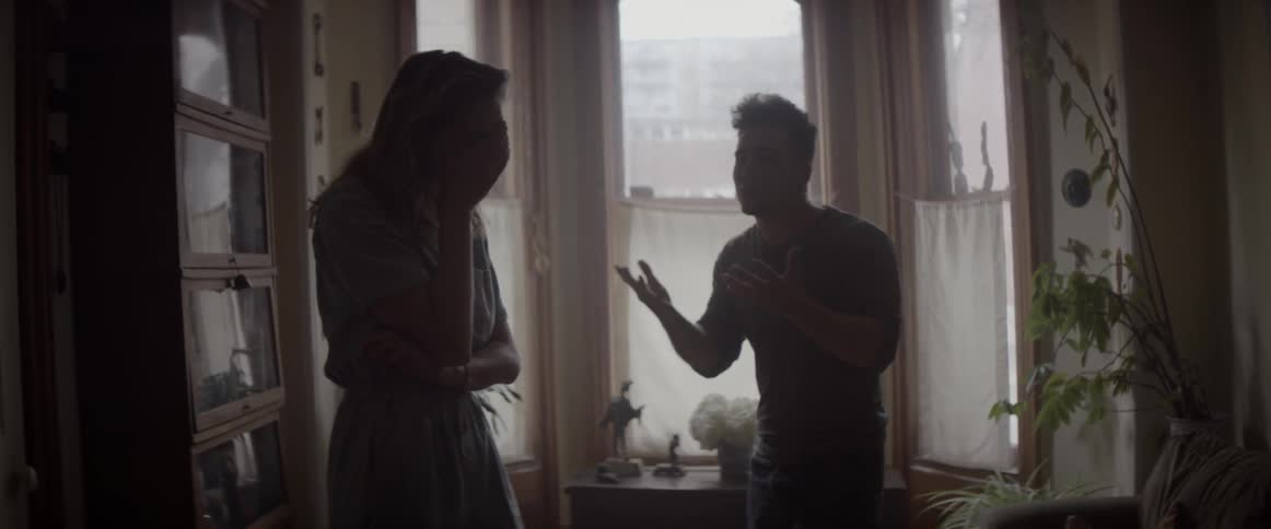 A couple are having an argument in a room during the day