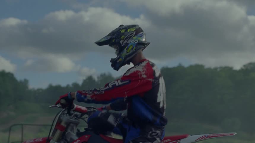 A motocross rider starts his bike and heads out to race