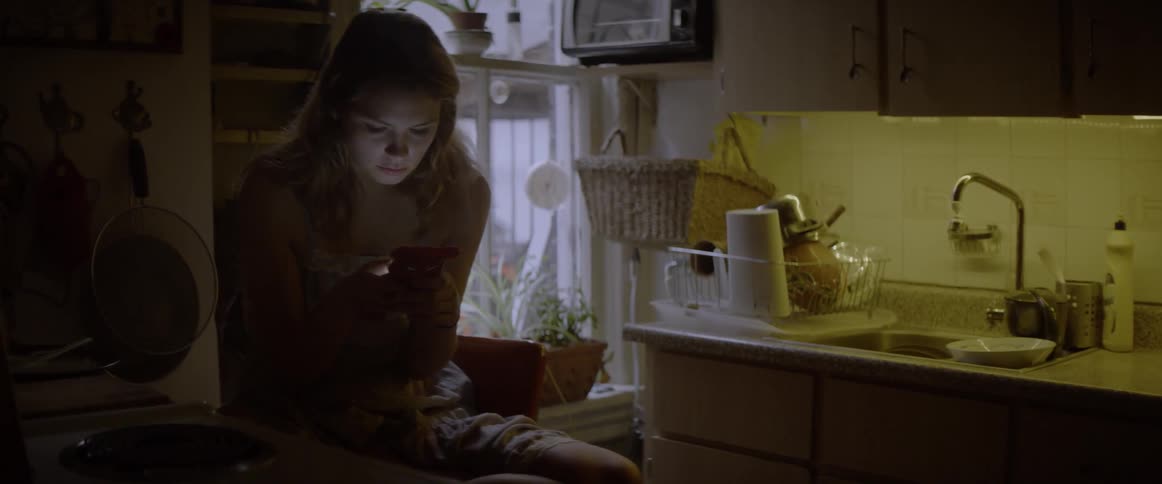 A blond girl types on her phone