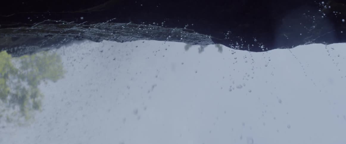 Rain drops falling from a rock on stormy day
