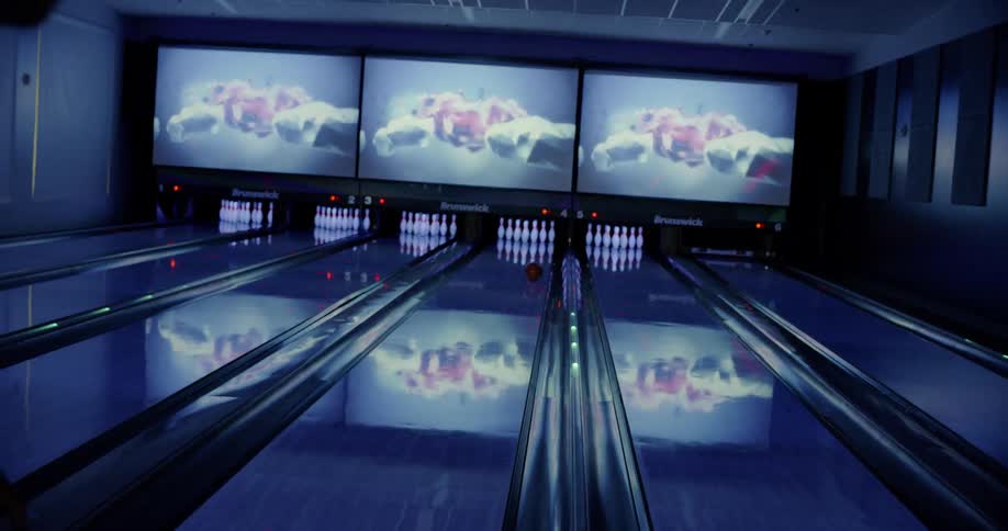 A man throws a bowling ball down a lane
