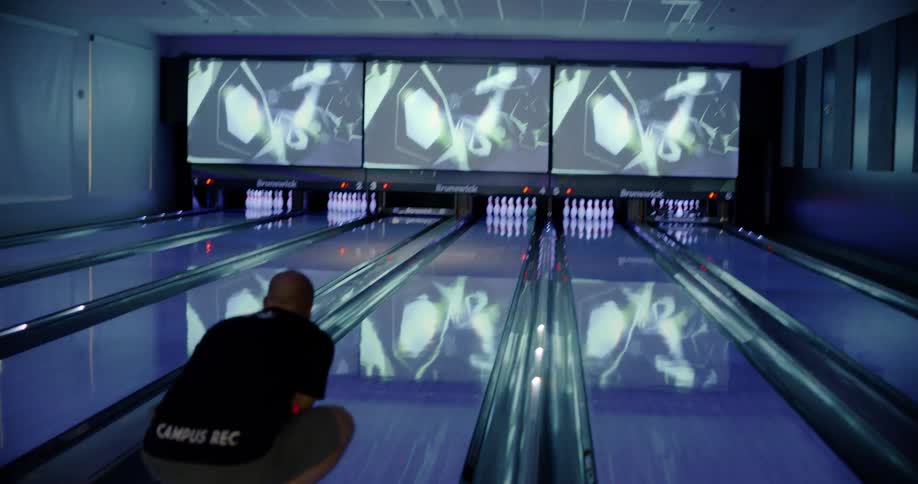 A man is bowling during the day