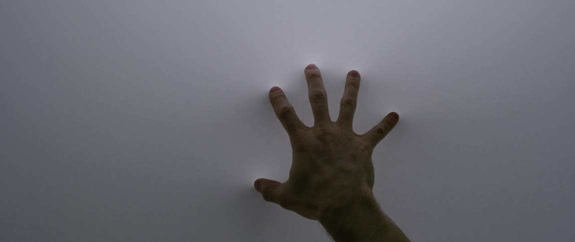 A person presses their finger on a fabric screen