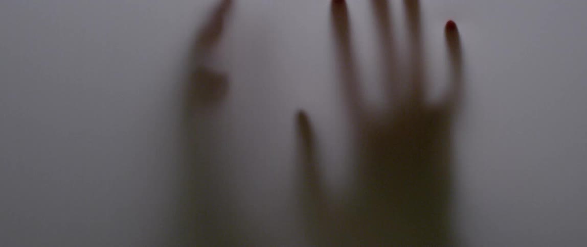 An opaque wall is being touched and pushed by a pair of hands