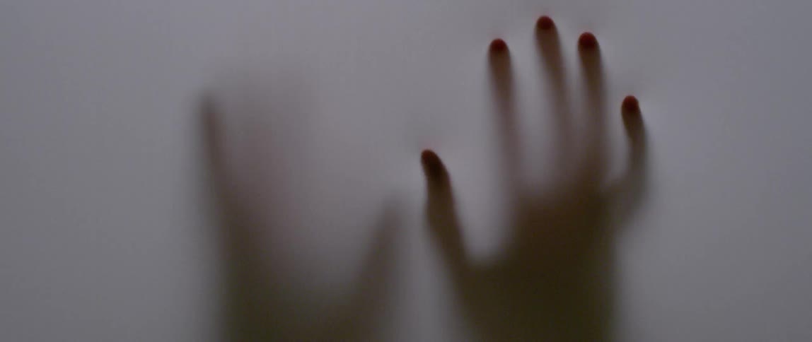 Hands are pressing against opaque fabric