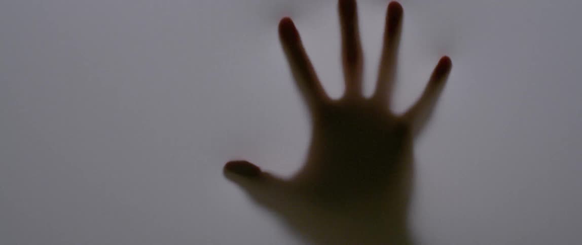 A hand touches a white fabric screen