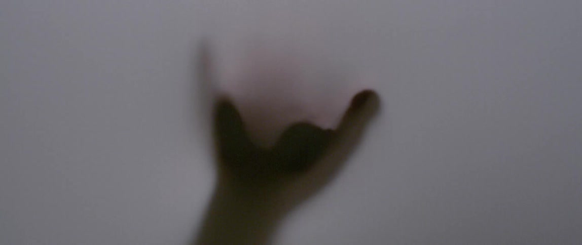 A hand is touching and pushing on an opaque fabric