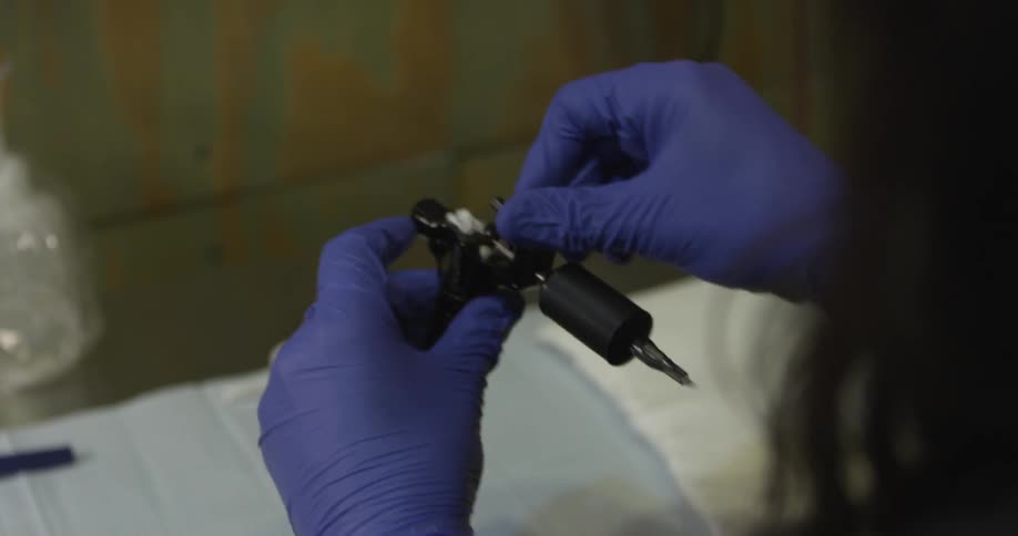 Man setting up a tattoo needle