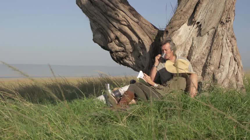 A man and woman read beneath a tree